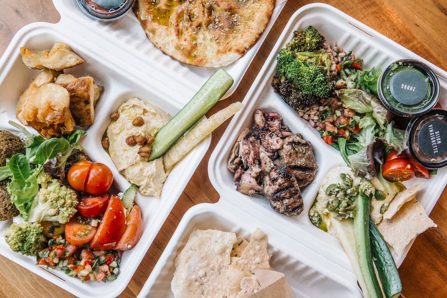 two take out containers full of food that can be purchased at rotisserie ema